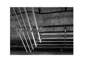 Neatly installed plumbing pipes in the ceiling by Iron Plumbing.